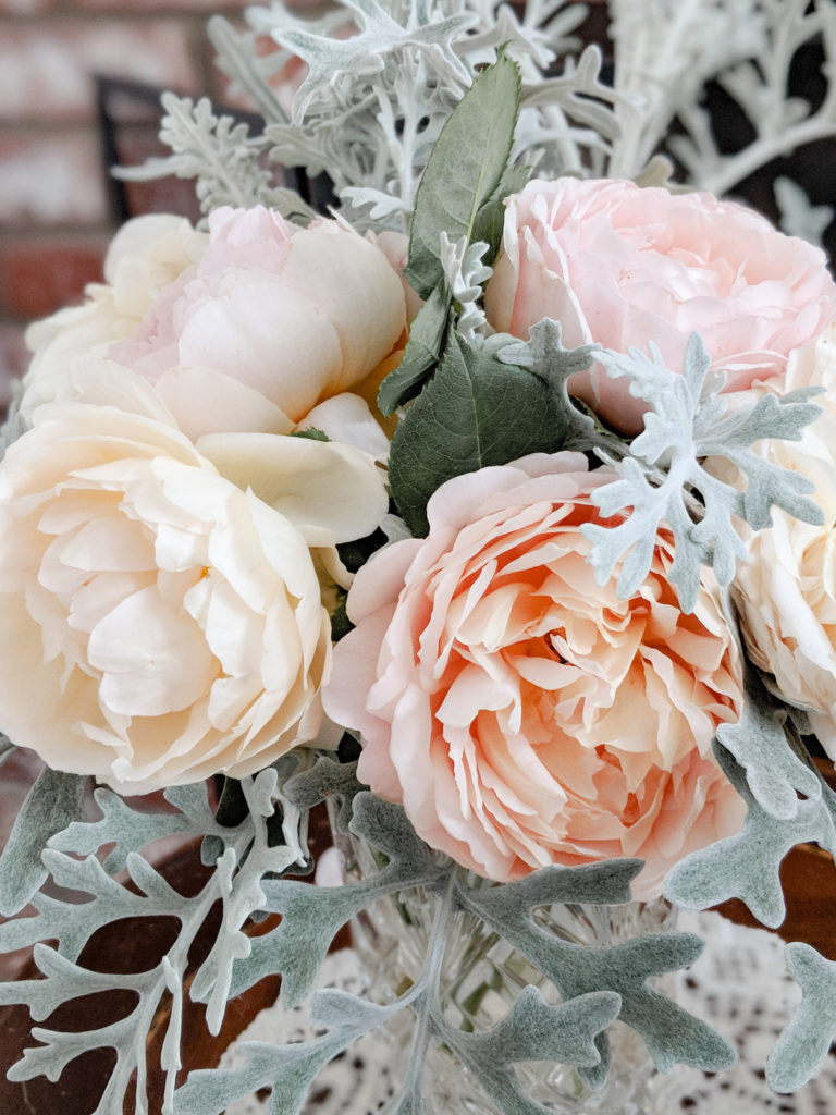 A vase filled with pink, peach, and cream roses, the results of my successful rose-growing adventures.