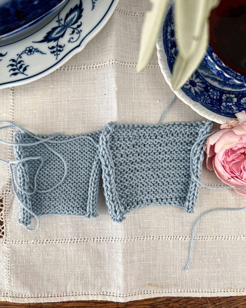 Two blue and white swatches are viewed top down with the bumpy reverse stockinette side facing up. The swatch on the left has even stitches. The swatch on the right has visible rowing out.