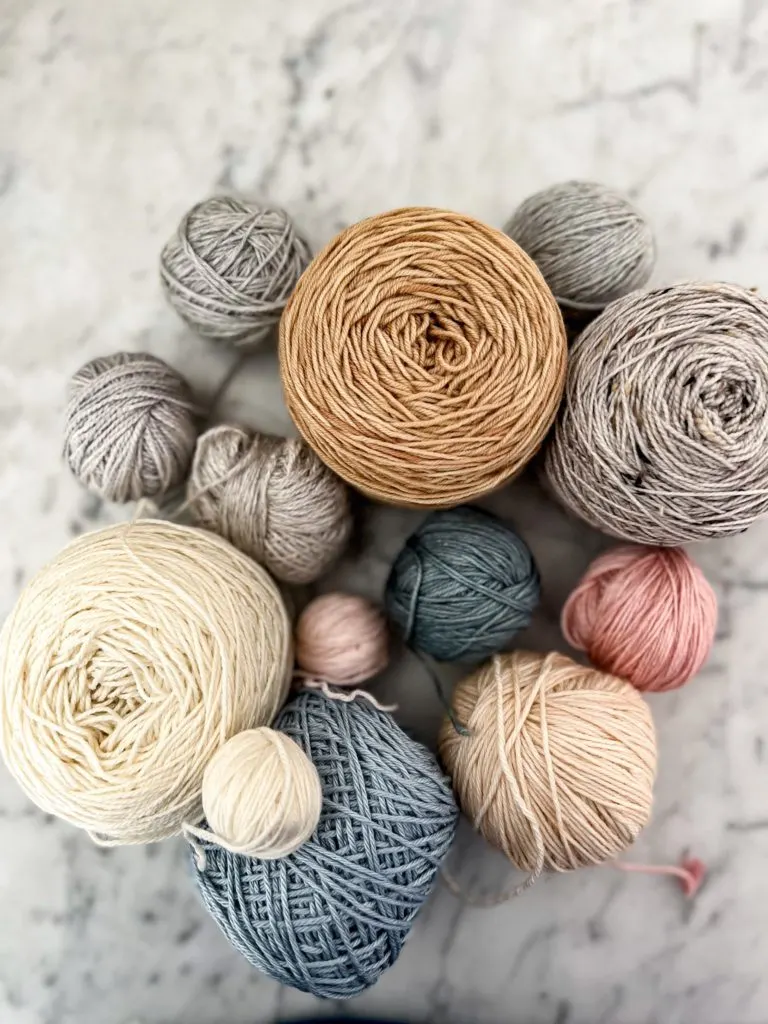 A collection of pastel yarns in different sized balls and cakes