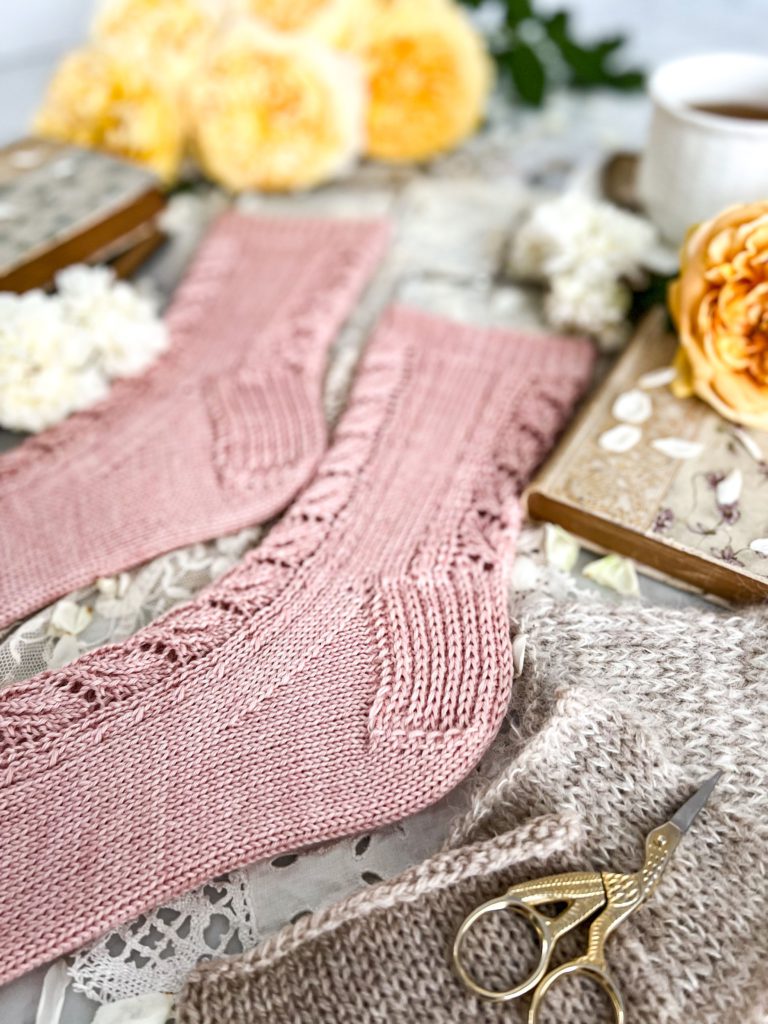 A close-up on a heel of a pair of pink socks. The heel is a reinforced heel flap and gusset.