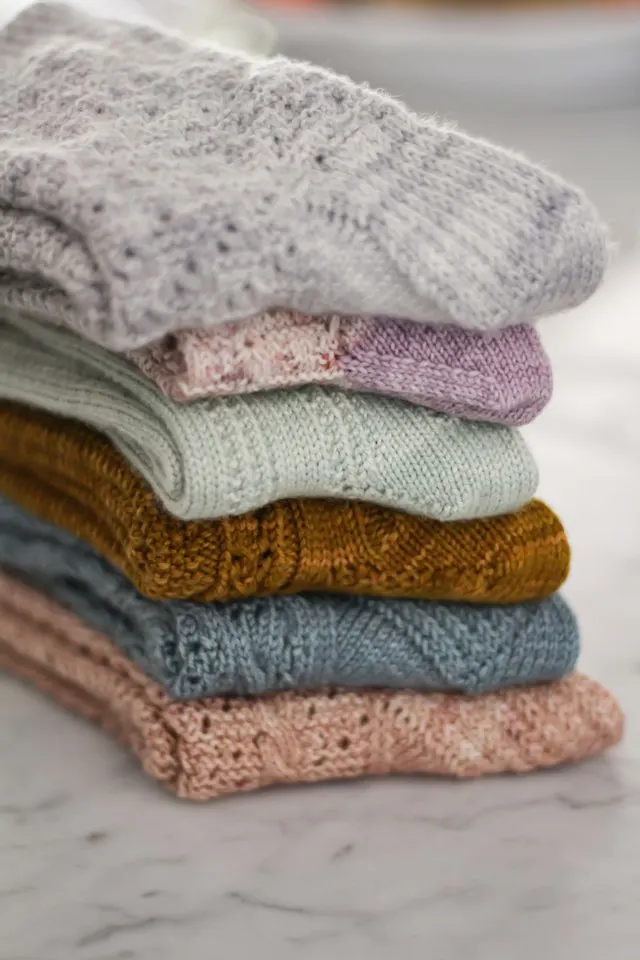 A stack of folded, pastel socks. The image is focused on the insteps.