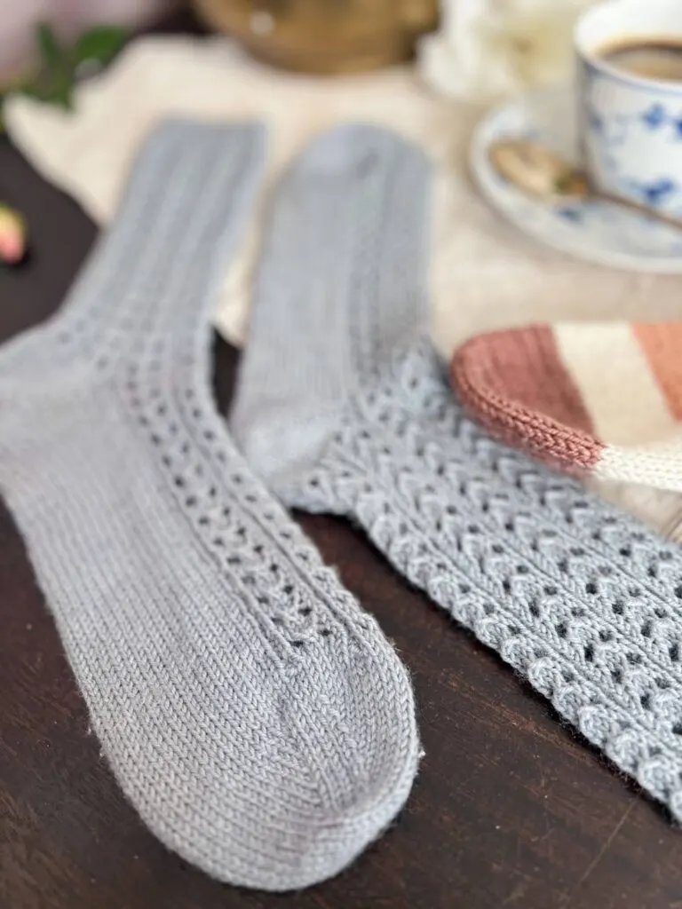 A close-up on one toe of a pair of light blue lacy knit socks. The pills have been removed and now the toe looks crisp and fresh again.