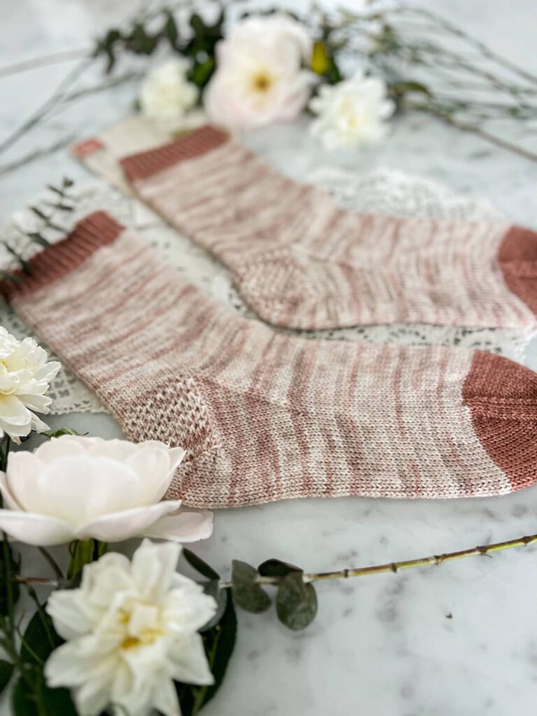 A close-up on the heel and gusset of a simple handknit sock. It shows the plain stockinette texture and Eye of Partridge heel.