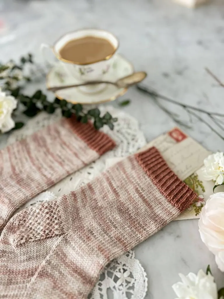 A close-up on the leg of a plain handknit sock. It shows the simple stockinette stitches and the Eye of Partridge heel.