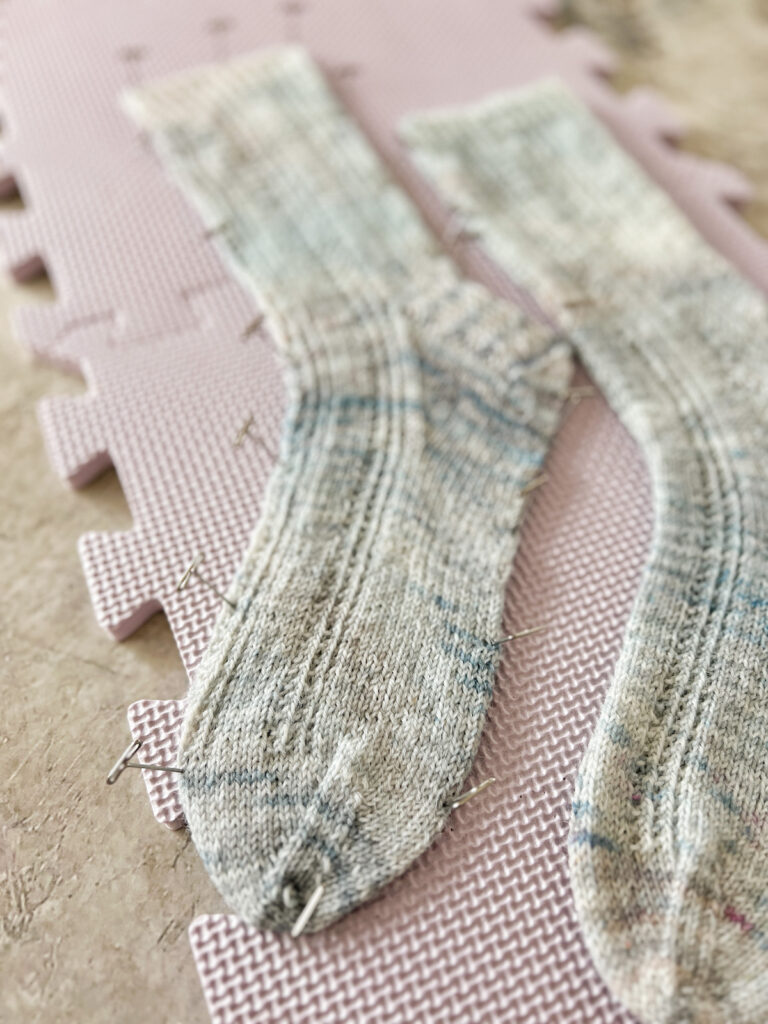 A close-up on the toe of a drying sock that has been pinned into place.