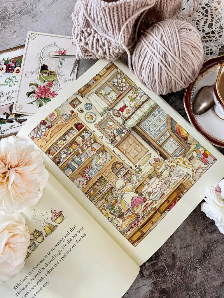 A flat-lay showing an inside page from The Complete Brambly Hedge. It shows a cozily cluttered kitchen inhabited by little mice in fluffy aprons and mobcaps. They're baking all sorts of delicate treats and pastries.