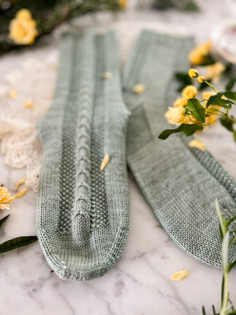 A close-up on the toes of the Madeleine Socks showing how the cable panel on the front flows toward the toe.