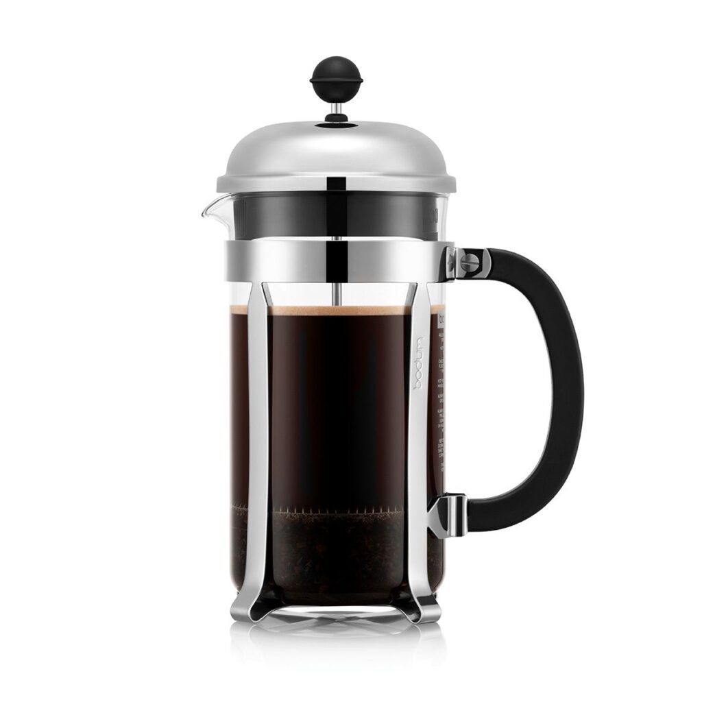 A French press with glass carafe, chrome lid and casing, and black plastic handle. The press is nearly full of fresh coffee.