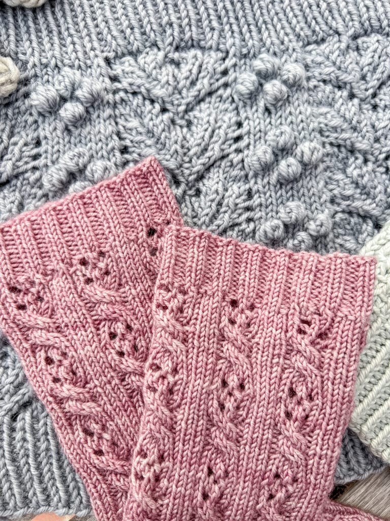 A close-up photo showing the 2 x 2 ribbing on the cuffs of a pink pair of handknit socks.