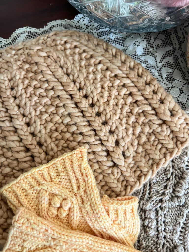 A close up on a chunky knit hat that uses twisted stitches in between columns of eyelets to make the knit stitches really pop.