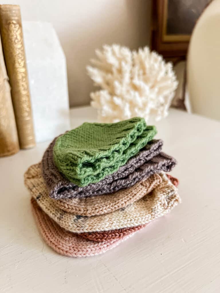 A stack of swatched sock toes and heels sits on top of a white dresser.